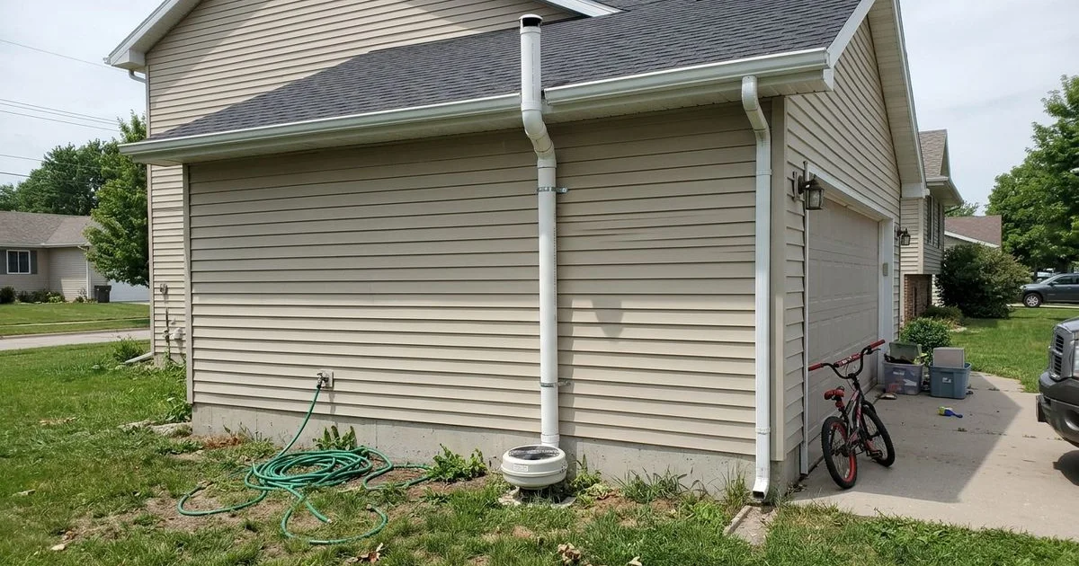Exterior radon mitigation pipe on a two-story Iowa home