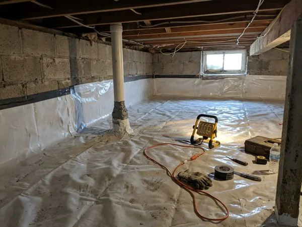 Crawlspace sealed with a heavy poly membrane and a radon suction pipe