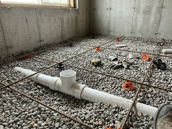 Sub-slab radon T-fitting set in gravel before a basement pour